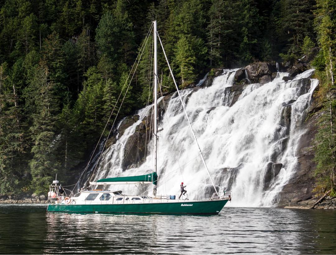 The Achiever rests in front of a waterfall.