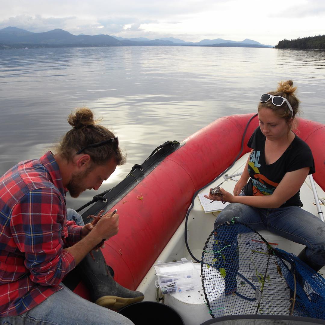 Two Raincoast scientists, one of them Justin Suraci on a zodiac boat
