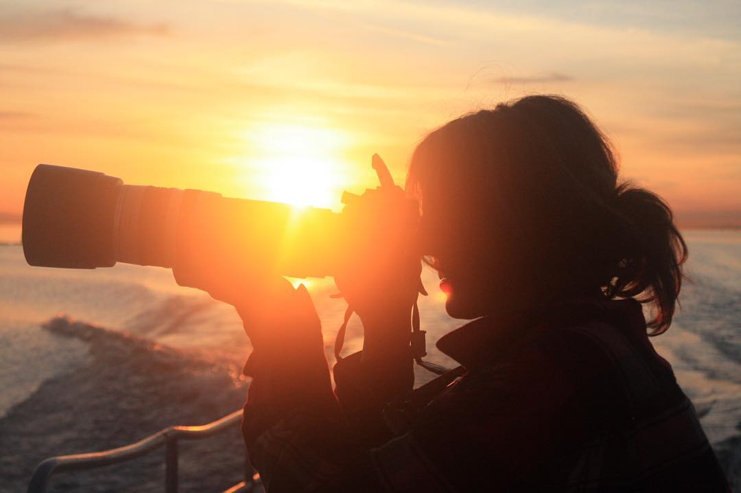 Silhouette of Misty Macduffee using a telescopic lens with the setting sen in the background