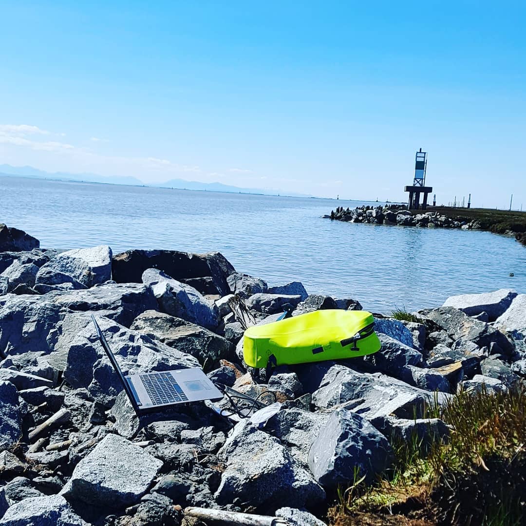 Laptop and flourescent yellow bag visible on the rocks near the Steveston jetty