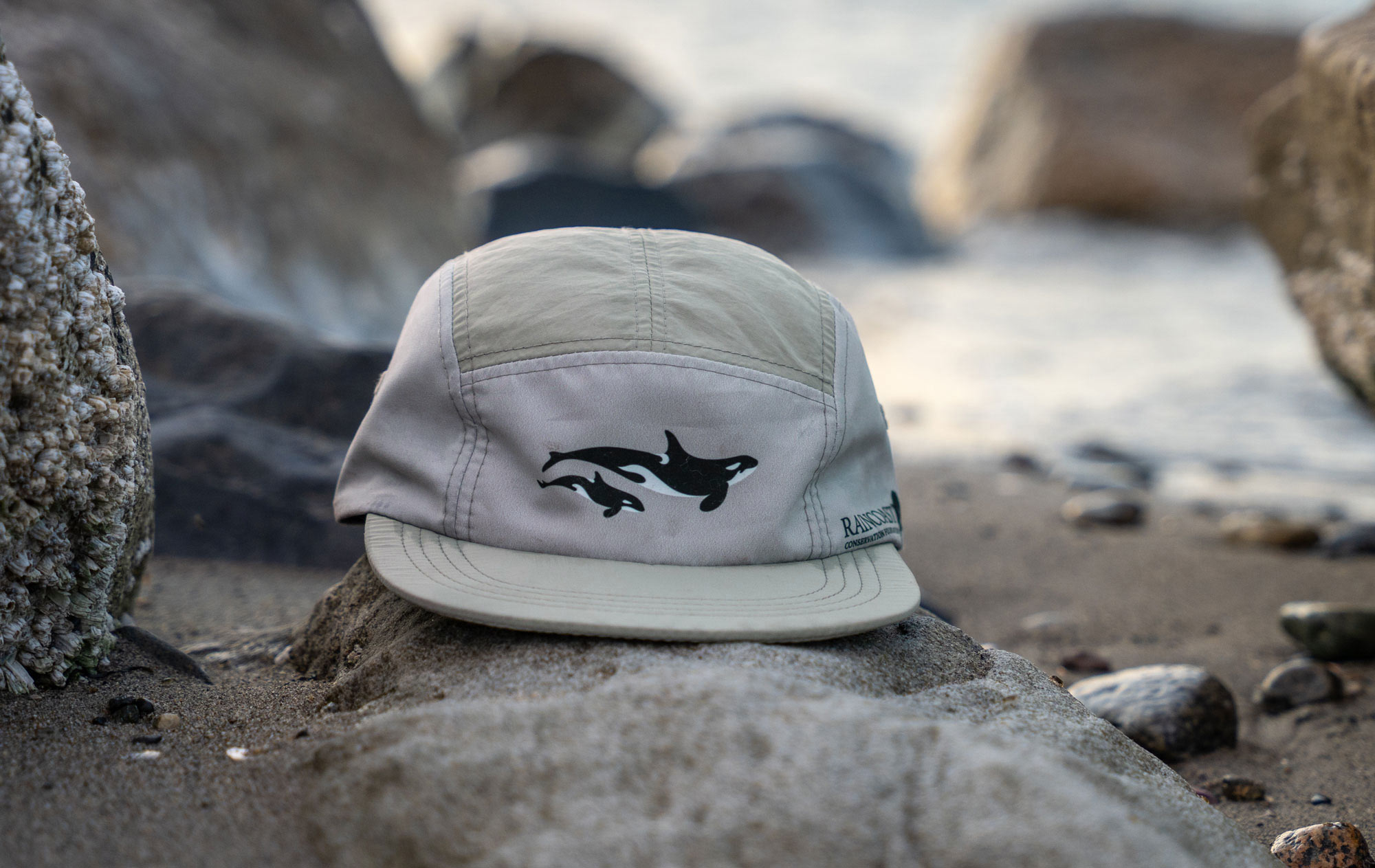 A light active gear hat with Raincoast logo and killer whales.